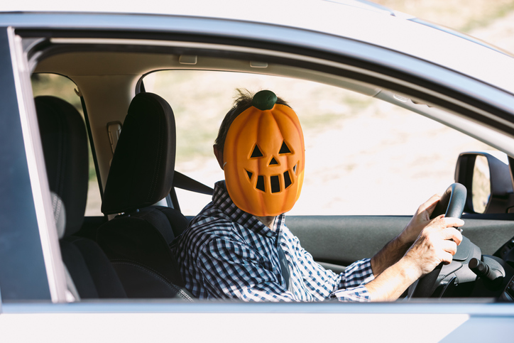 man with pumpkin mask in car