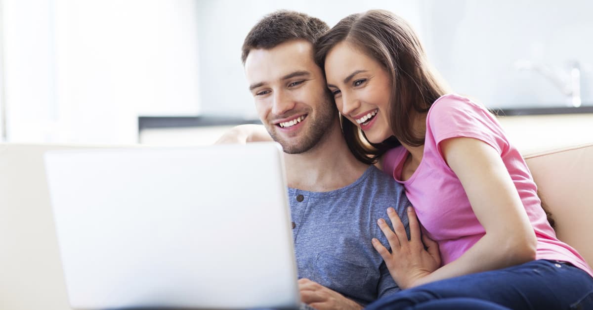 Couple-Sitting-On-Couch-Searching-For-Home-Insurance