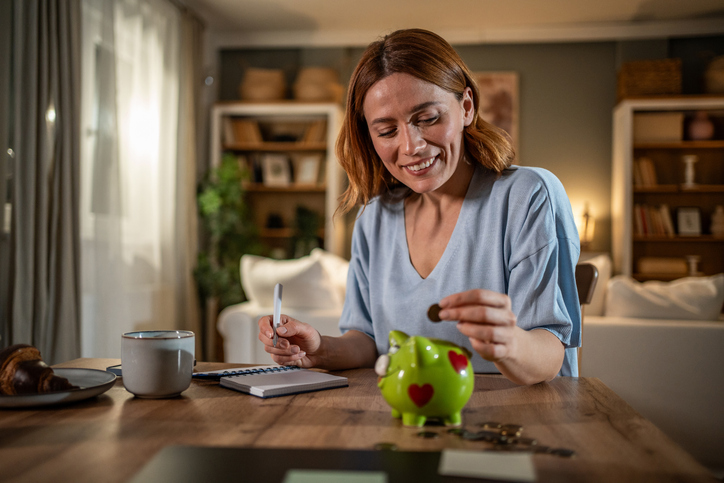Woman putting money into piggy bank