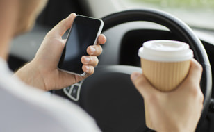 Person Holding Phone And Coffee While Driving