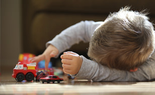 Child Playing With Car That Has Broken Down