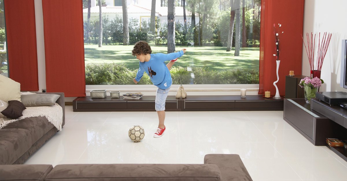 Boy-Kicking-Football-Indoors