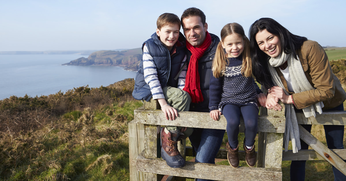 Happy-Family-Standing-At-A-Cliff