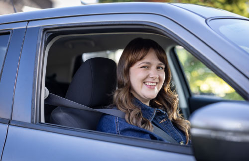 Man smiling while driving car