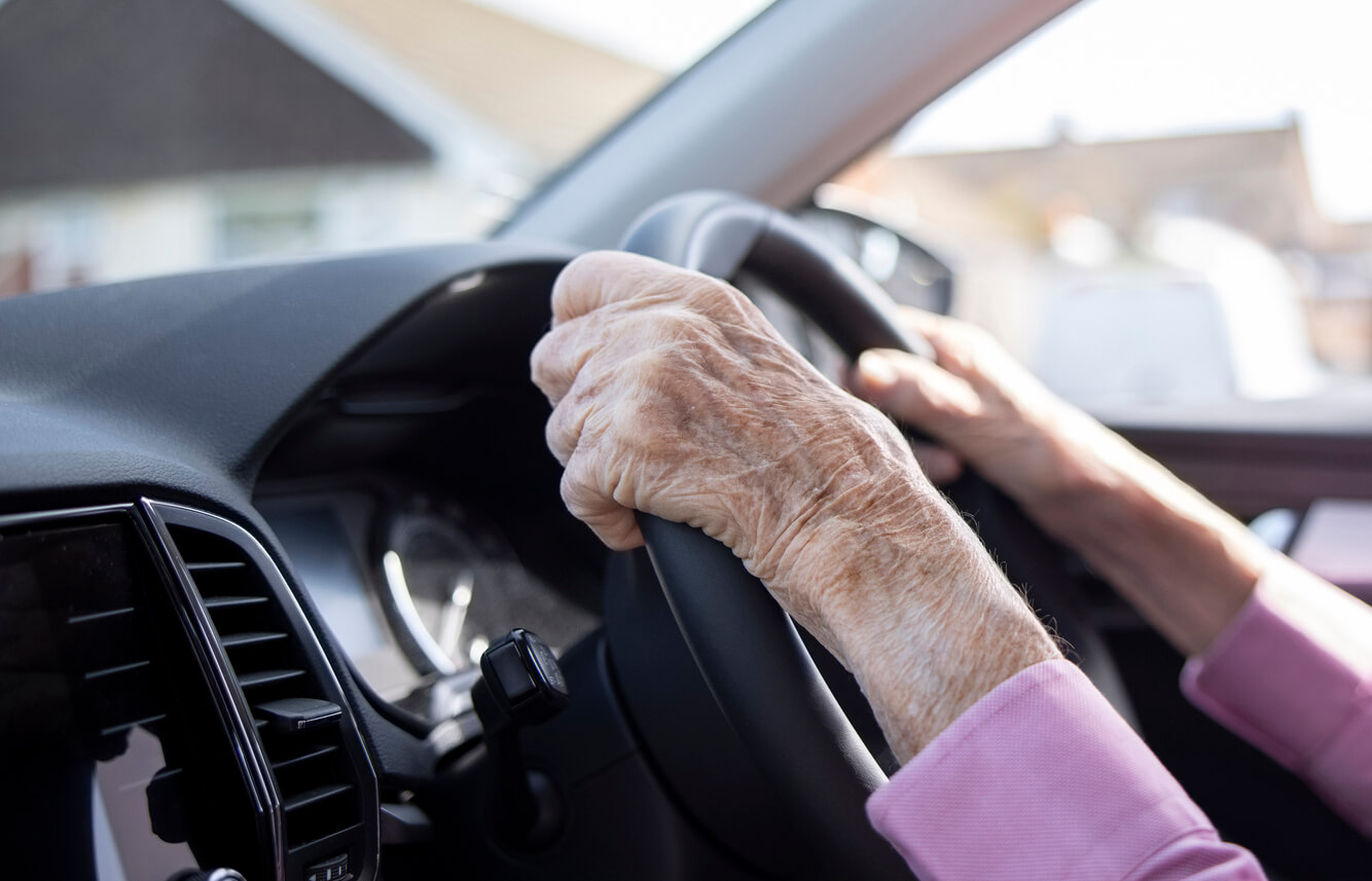 Older driver steering a car