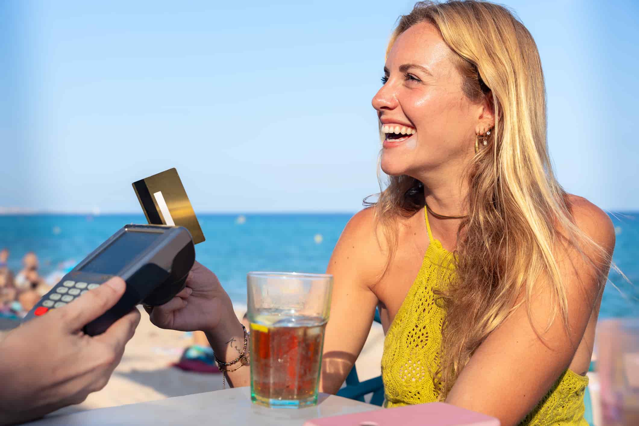 Young woman holding a credit card and making a payment transaction.