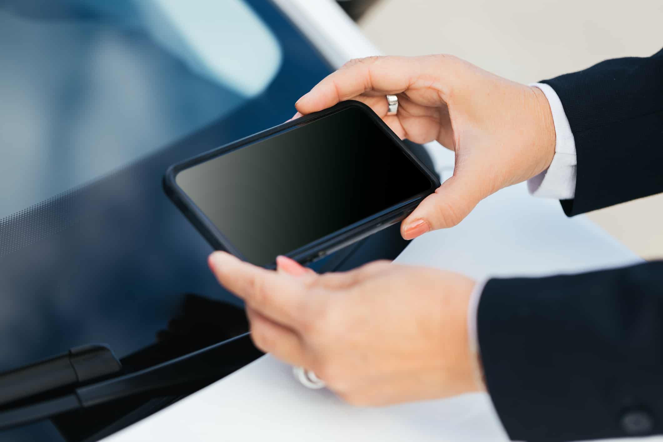 Driver using a phone to find their car's VIN number